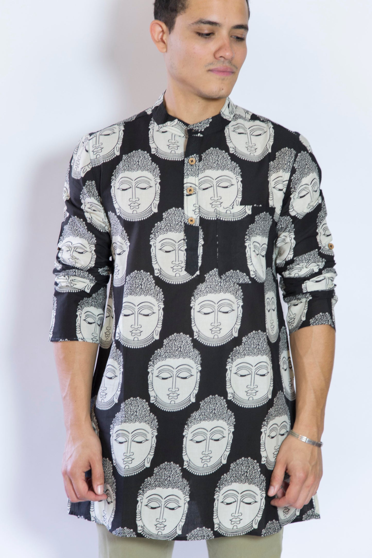 Quiet and Still. The Buddha in Black. This loose fitting and airy Kurta pairs well with some chinos and desert boots. Long sleeves to be kept stretched out or rolled up in place with wooden buttons on the elbows to maintain that cool and casual vibe. 100% Cotton Chest and Side Pockets Regular Fit Made in India